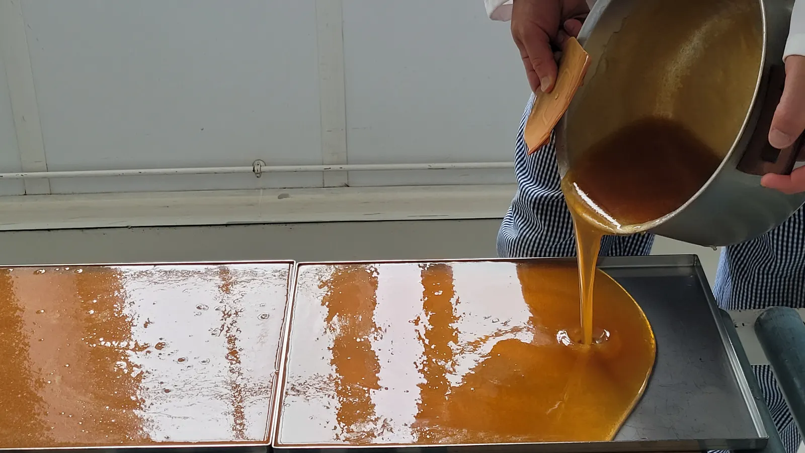 La pâte de fruit brûlante, coulée sur la plaque dans l’atelier